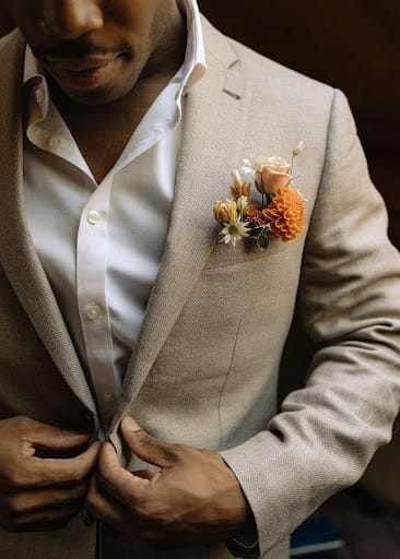 Man in suit decorated with floral boutonniere.